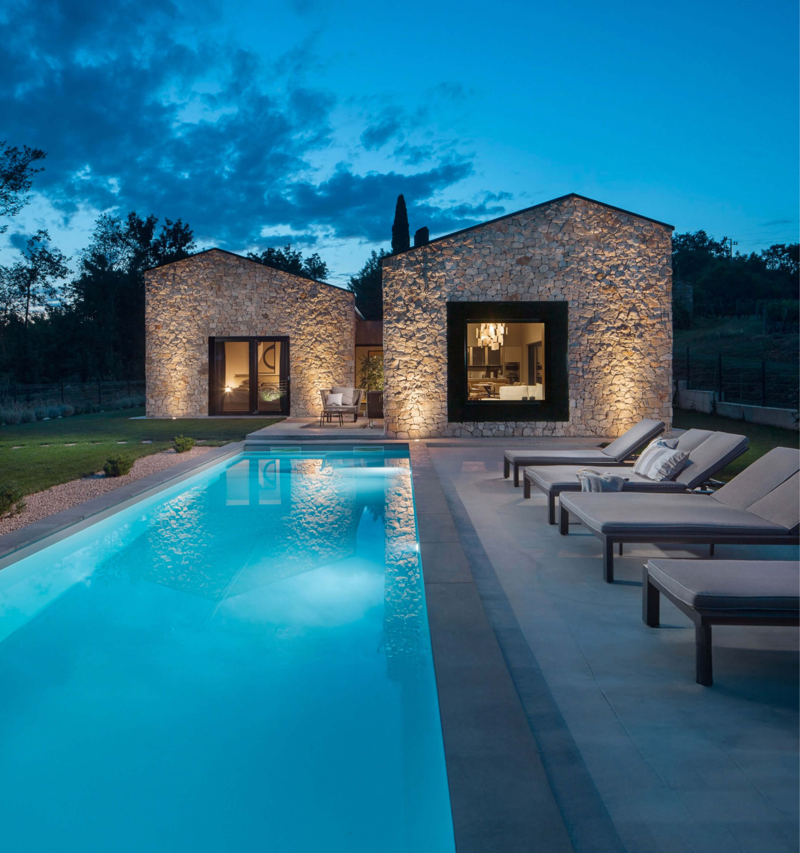 Sonnenliegen am beheizten Pool in der Villa Ulmus bei Nacht