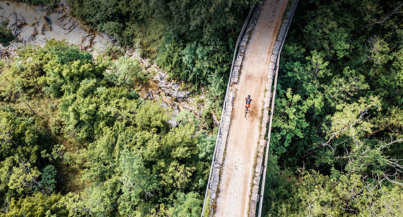 Luftaufnahme eines Radfahrers auf einem Brückenpfad, umgeben von istrischer Natur