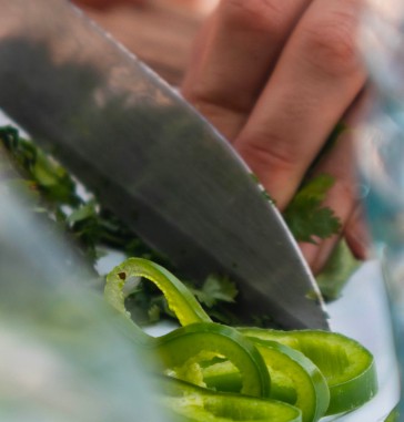 Vegetables and herbs being cut by a knife