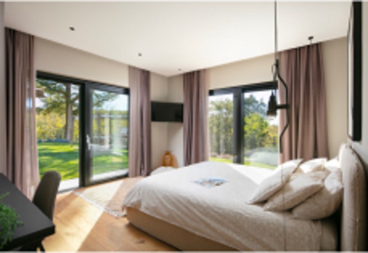 Large master bedroom with a double bed and two sliding doors leading to the garden